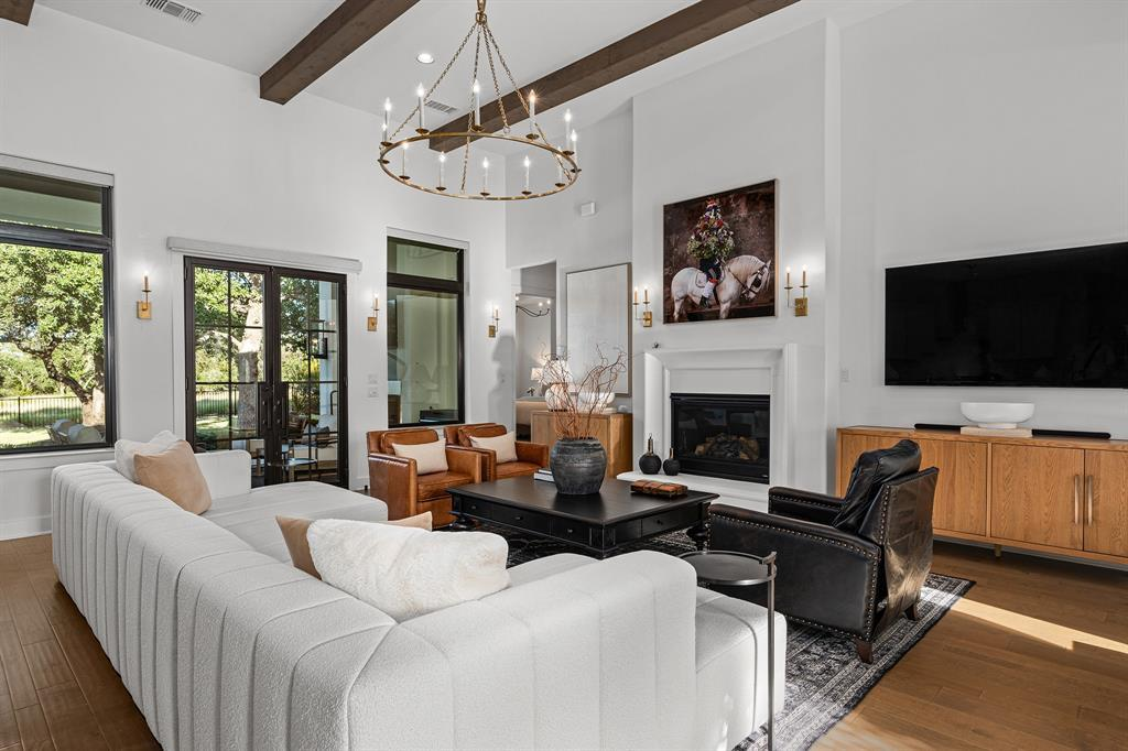 Living room with fireplace, chandelier and view to backyard through French doors
