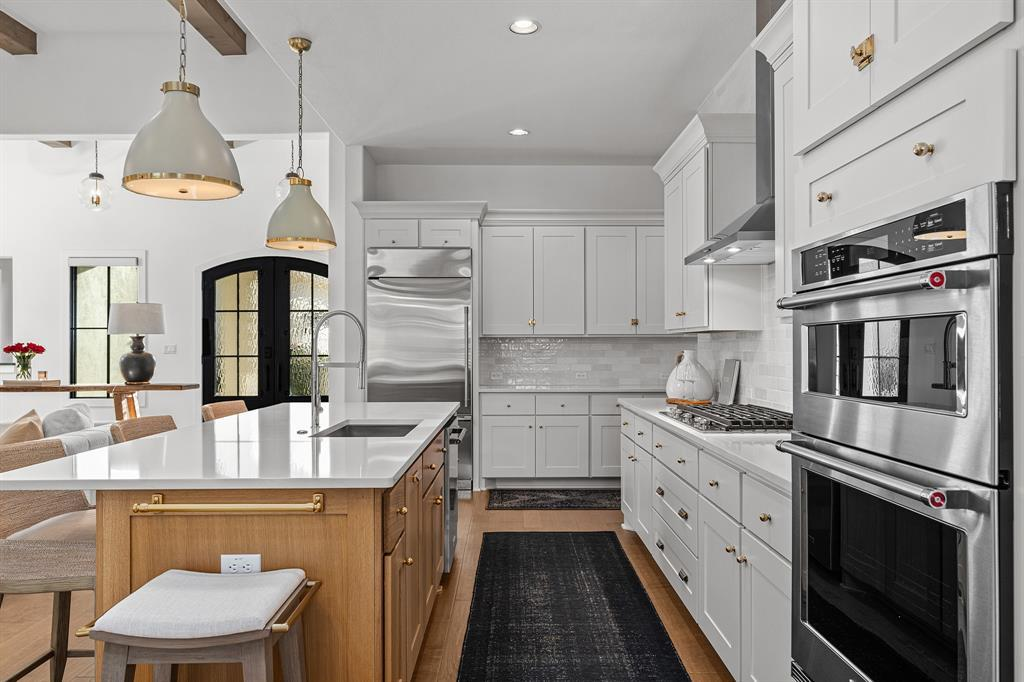 Chef's kitchen with oversized island, quartz countertops and Monogram refrigerator