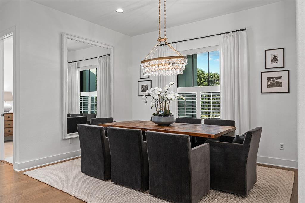 Formal dining room with crystal chandelier, reclaimed wood table and plantation shutters