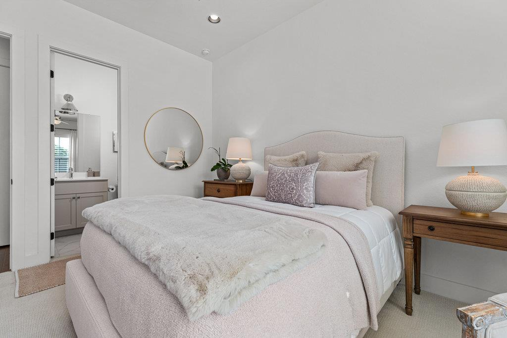 En-suite bedroom with gold mirror, designer bedding and en-suite bath