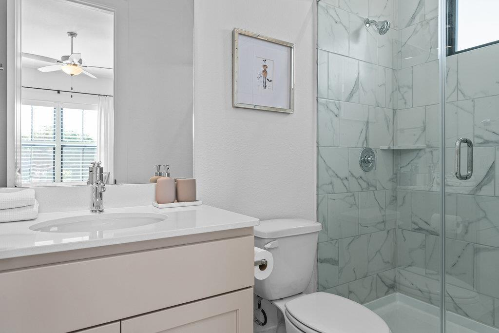 Secondary en-suite bathroom with marble tile shower and quartz vanity