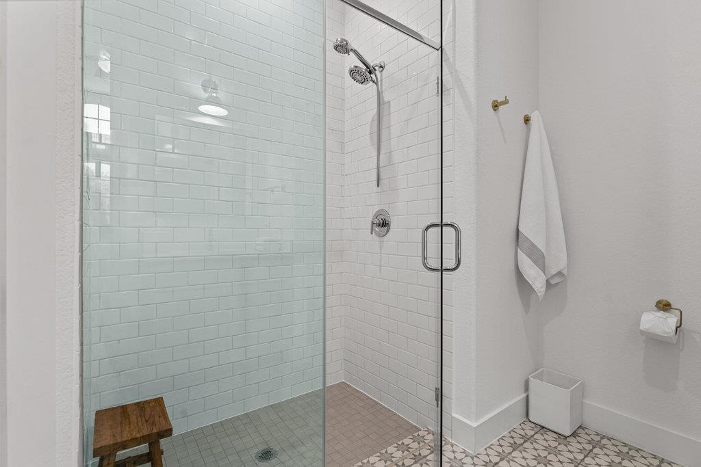 Casita walk-in shower with white subway tile and patterned floor tile