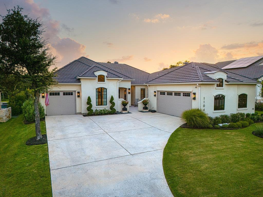 1104 Flint Ridge Trl — front exterior at dusk with 3-car garage, Cimarron Hills Georgetown TX